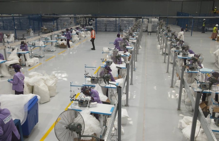 Workers at sewing stations on the floor of a mosquito net factory