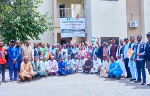 Health officials from Nigeria and Niger pose for a group photograph, holding both national flags